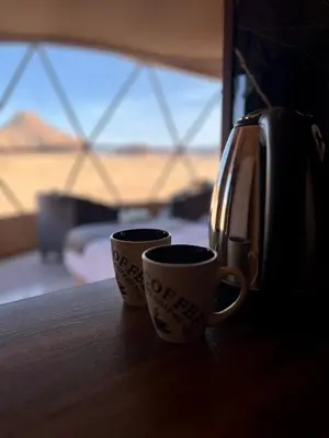 two coffee cups sitting on a table next to a toaster at Rum Four Seasons luxury Camp & Jeep Tours in Wadi Rum