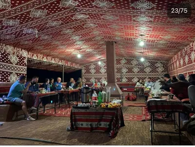 a group of people sitting at tables in a restaurant at Bedouin Memories Camp in Wadi Rum