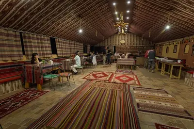 a large room with many carpets on the floor at Wadi Rum Trip Bedouin Camp in Wadi Rum