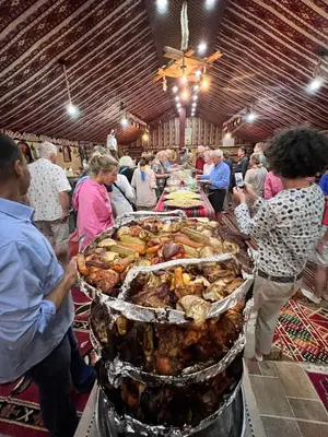 a group of people standing around a buffet of food at Wadi Rum Trip Bedouin Camp in Wadi Rum