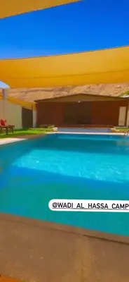 a swimming pool in front of a building at Wadi Al-Hassa camp in Khawkhah