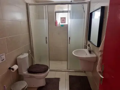 a bathroom with a shower and a toilet and a sink at Rainbow Guest House in Amman