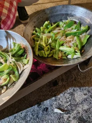 a bowl of green beans and onions in a pan at Rainbow Guest House in Amman