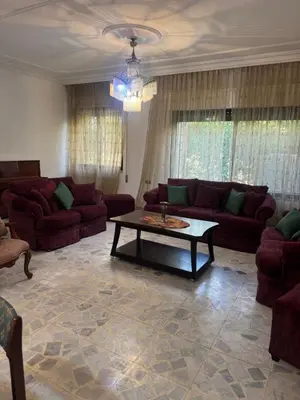 a living room with couches and a coffee table at Abdoun ground floor apartment in Amman