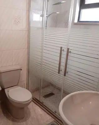 a bathroom with a shower and a toilet and a sink at Abdoun ground floor apartment in Amman