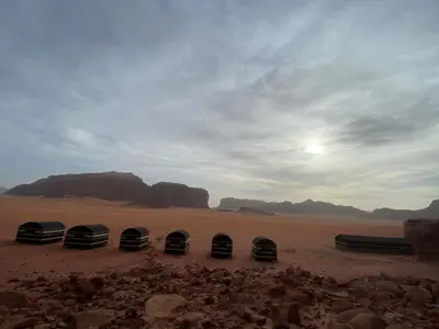 a group of three tents in the desert at Wadi Rum Odyssey Camp in Wadi Rum