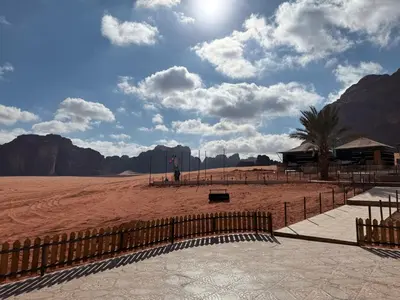 a view of a desert with mountains and a fence at falling Stars Camp in Wadi Rum