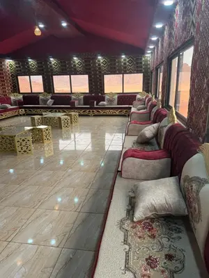 a room with many couches and tables in a room at falling Stars Camp in Wadi Rum