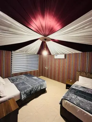 a bedroom with two beds and a ceiling at Sandy Camp Wadi Rum in Wadi Rum