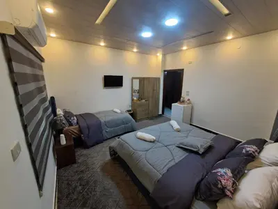 a bedroom with two beds and a tv in it at Hadrian's Arch in Jerash