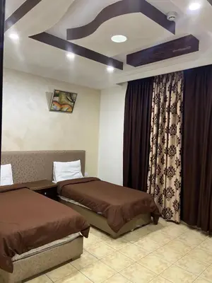 a hotel room with two beds and a window at Shihan hotel suites in Amman