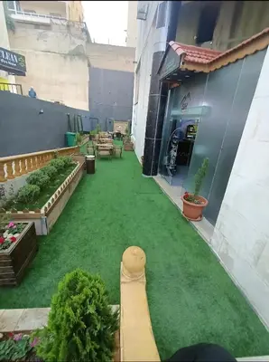 a courtyard of a building with green grass at Shihan hotel suites in Amman