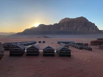 a group of tents in the desert with a mountain at Rum Magic Nights in Wadi Rum