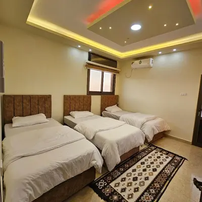 a room with three beds and a window at Authentic boutique in Wadi Musa