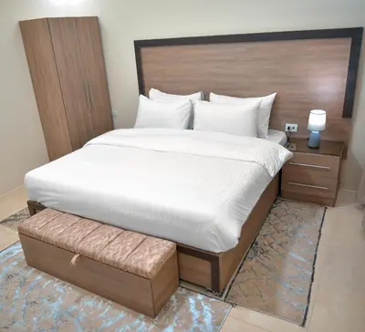 a bedroom with a large bed with a wooden headboard at Beit Alshabaan Inn in Wadi Musa