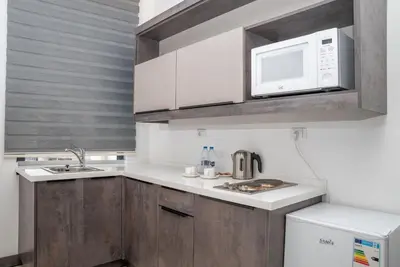 a kitchen with a microwave and a sink at Liv Weibdeh Hotel Suites in Amman