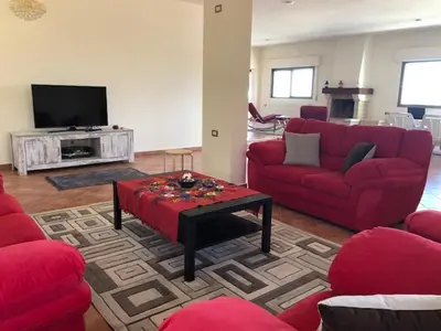 a living room with red couches and a tv at Charming House in Amman + Balcony in Amman