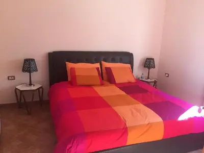 a bedroom with a colorful bed with two lamps at Charming House in Amman + Balcony in Amman