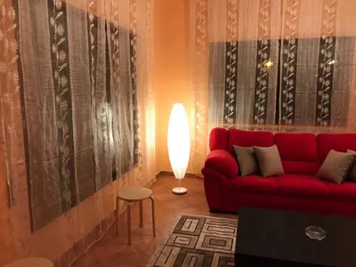 a living room with a red couch and a lamp at Charming House in Amman + Balcony in Amman