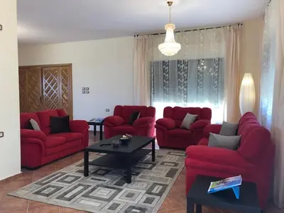 a living room with red couches and a table at Charming House in Amman + Balcony in Amman