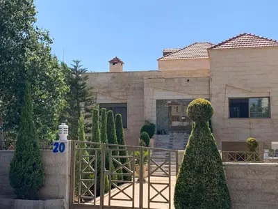 a house with a fence and trees in front of it at Charming House in Amman + Balcony in Amman
