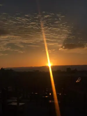 a sunset with the sun shining in the sky at Safi Kitchen Hostel in Aş Şāfī
