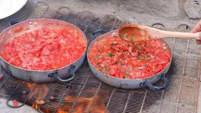a pot of stew on a grill with a wooden spoon at Safi Kitchen Hostel in Aş Şāfī
