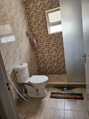 a bathroom with a toilet and a window at شقة مفروشة في ام اذينة in Amman