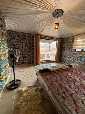 a bedroom with a bed with pink flowers on it at Wadi Rum Magic Camp in Wadi Rum