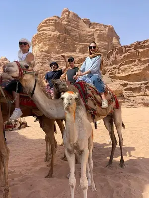 a group of people riding on camels in the desert at Wadi Rum Magic Camp in Wadi Rum