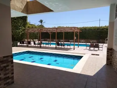 a swimming pool with a table and a pavilion at Dead sea 2 bedroom apartment in Astana ,swemeh Jordan in Sowayma
