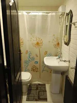 a bathroom with a shower curtain with a sink and a toilet at Dead sea 2 bedroom apartment in Astana ,swemeh Jordan in Sowayma