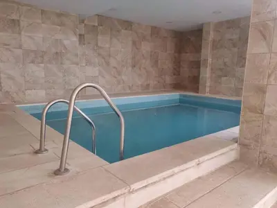 a large swimming pool with blue water in a room at Dead sea 2 bedroom apartment in Astana ,swemeh Jordan in Sowayma
