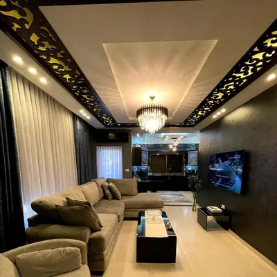 a living room with a couch and a chandelier at Alghalayieny Modern Apartments in Amman