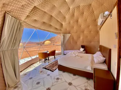 a bedroom with a bed and a large window at Katrina Rum camp in Wadi Rum
