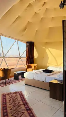 a bedroom with a bed and a large window at Katrina Rum camp in Wadi Rum