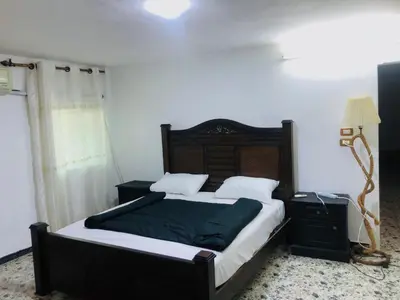 a bedroom with a large bed with a wooden headboard at Jerash -HeritageHotel in Jerash