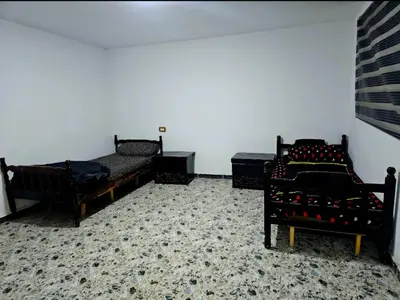 a room with two beds and two chairs at Jerash -HeritageHotel in Jerash