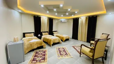 a hotel room with two beds and a chair at Petra Olive House in Wadi Musa