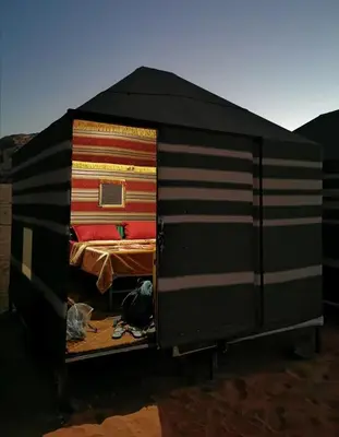 a room with a bed with colorful blankets at Wadi Rum Local Guide in Wadi Rum