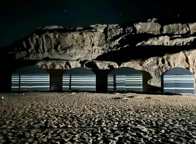 a group of three benches in front of a rock wall at Wadi Rum Local Guide in Wadi Rum