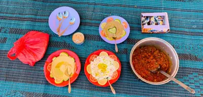 a table with plates of food and a pot of soup at Wadi Rum Local Guide in Wadi Rum