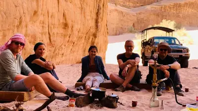 a group of people sitting in the desert at Wadi Rum Local Guide in Wadi Rum