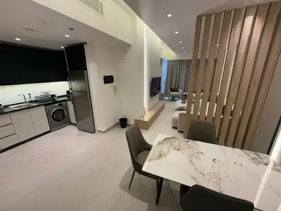 a large living room with a table and a kitchen at Damac Tower Amman - Luxury Studio - استوديوهات فاخرة - داماك عمان العبدلي in Amman