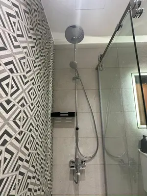 a bathroom with a shower with a wall at Damac Tower Amman - Luxury Studio - استوديوهات فاخرة - داماك عمان العبدلي in Amman