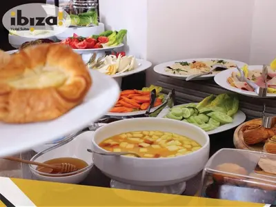 a buffet with plates of food and bowls of vegetables at Ibiza Hotel in Amman