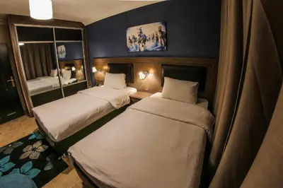 a room with two beds in a room with a mirror at Ibiza Hotel in Amman