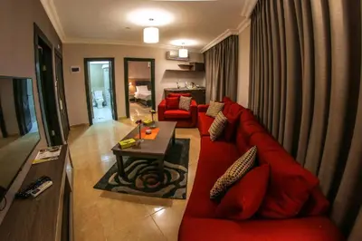 a living room with a red couch and a table at Ibiza Hotel in Amman