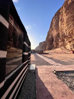 a train is traveling through the desert near a mountain at Adam Bedouin camp in Wadi Rum