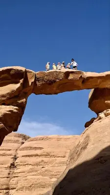 a group of people standing on a rock formation at Enad desert camp in Wadi Rum